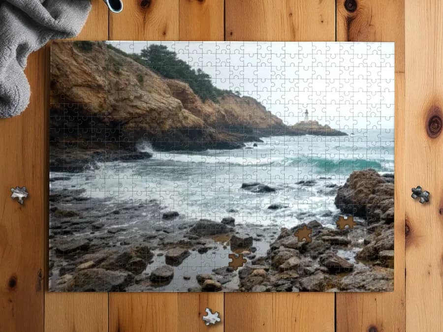 Assembled 500-piece puzzle of: A rocky coastline with a distant lighthouse